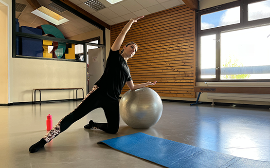 femme avec bras sur un gros ballon pilates polyèdre seynod annecy