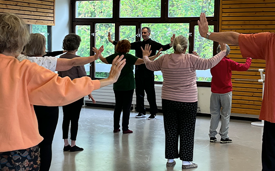 groupe de personnes de dos avec bras parallèle au sol qi gong polyèdre seynod annecy