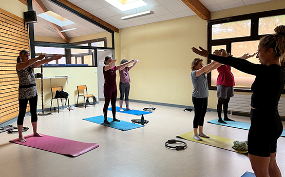 groupe de femme bras en l'air debout sur tapis pilates polyèdre seynod annecy