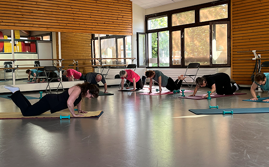 groupe de personnes sur tapis de sport en position pompe avec altères polyèdre seynod annecy