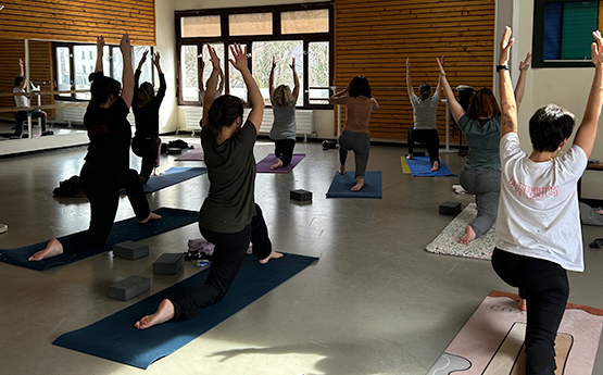 personnes sur tapis en position de yoga avec bras en l'air polyèdre seynod annecy
