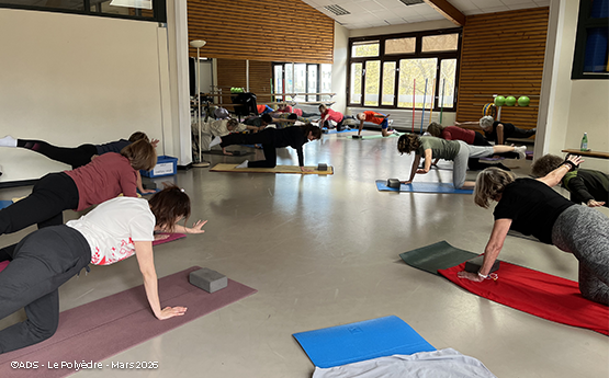personnes sur tapis en position pilates avec bras en l'air polyèdre seynod annecy