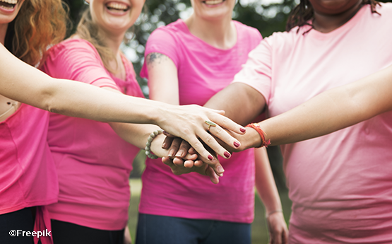 groupe de femmes qui se tiennent les mains en rose
