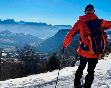 homme de dos en montagne qui regarde la vue polyèdre seynod annecy