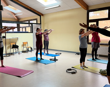 groupe de femme bras en l'air debout sur tapis pilates polyèdre seynod annecy