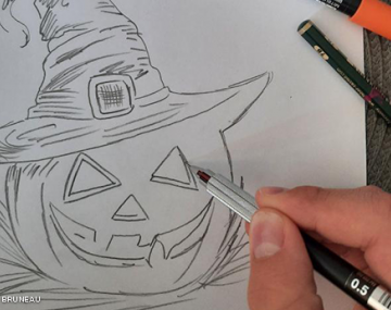 main garçon avec crayon qui dessin une citrouille polyèdre seynod annecy